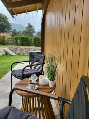 a wooden table with cups and mugs on a patio at Boutique Holiday Pirin Golf in Razlog