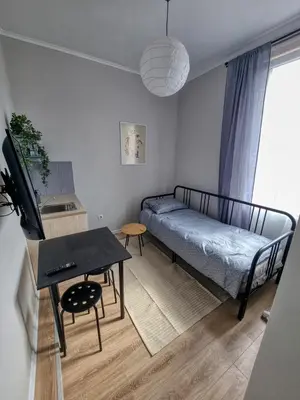 a small living room with a bed and a table at Sunny Studio in Sofia Center in Sofia