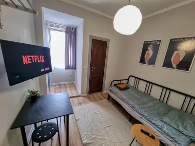 a living room with a bed and a tv on the wall at Comfortable Studio in Sofia City in Sofia