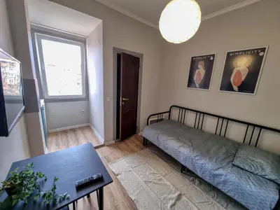 a room with a bed and a table and a window at Comfortable Studio in Sofia City in Sofia