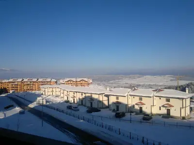 a group of buildings with snow on the roofs at Harriet Hill Designer Bansko in Bansko