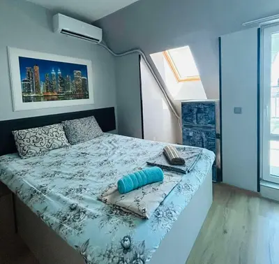 a bedroom with a bed with a blue comforter at Joy Station Appartment 2 in Sofia