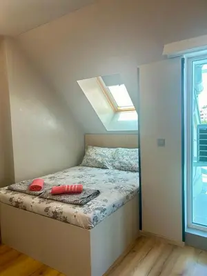 a small bedroom with a bed with a window at Joy Station Appartment 2 in Sofia