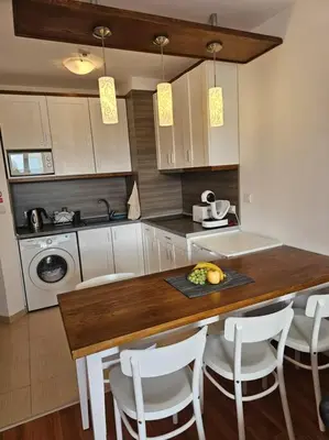 a kitchen with a counter with a table and chairs at Bansko Private VIP Apartment in Bansko