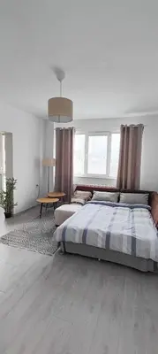 a bedroom with a large bed and a table at 5munutes from the airport & 15 from the City center in Sofia