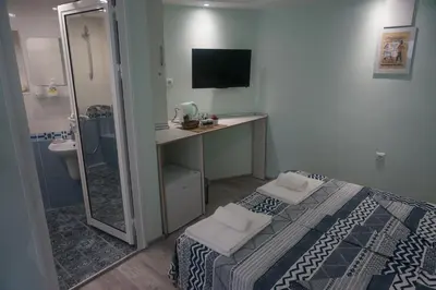 a bedroom with a bed and a desk and a mirror at DaRoom in the heart of Plovdiv in Plovdiv