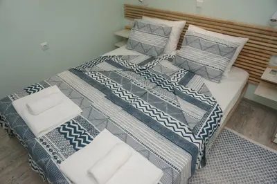 a bed with blue and white blankets and pillows at DaRoom in the heart of Plovdiv in Plovdiv