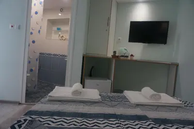 a bathroom with a bed with towels and a mirror at DaRoom in the heart of Plovdiv in Plovdiv