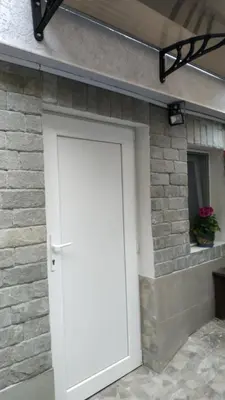 a white door on a brick building with a window at DaRoom in the heart of Plovdiv in Plovdiv