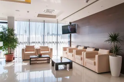 a lobby with couches and a tv on a wall at Hotel Dream in Sofia