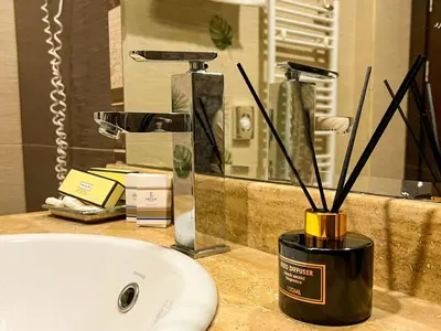 a bathroom sink with a vase with sticks in it at Hotel Dream in Sofia