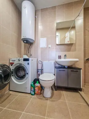 a bathroom with a toilet and a sink and a washing machine at Cozy 2BD Apartment in Bansko by Flat Mаnager in Bansko