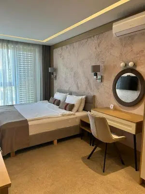 a bedroom with a bed and a desk and a mirror at City Park Inn - Art Gallery in Plovdiv