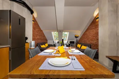 a dining room with a wooden table with plates on it at Industrial-style 2BD Loft with Parking Spot by Flat Mаnager in Plovdiv