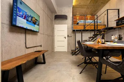 a room with a table and a tv on a wall at Industrial-style 2BD Loft with Parking Spot by Flat Mаnager in Plovdiv