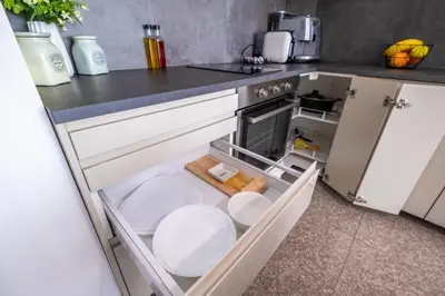 a kitchen with an open drawer in the floor at Modern Apartment 3 with Parking next to Bulgaria Mall in Sofia
