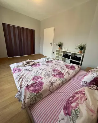 a bedroom with a large bed with pink flowers at Rio Sunny 2BDR Apt near NDK - Metro - non-stop paid public Parking in Sofia
