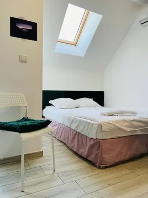 a bedroom with a bed and a chair and a window at Little Jack With Terrace in Sofia