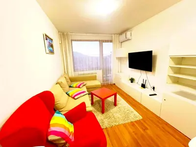 a living room with a red couch and a television at VIP Apartment Belvedere Club in Bansko
