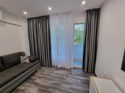 a living room with a couch and a large window at Apartment's Ortakchiev in Sofia