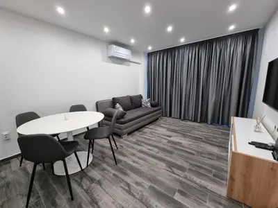 a living room with a couch and a table and chairs at Apartment's Ortakchiev in Sofia