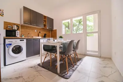 a kitchen with a table and chairs and a washing machine at Apartment in the city center in Plovdiv