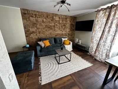 a living room with a couch and a table at Апартамент НИА in Velingrad